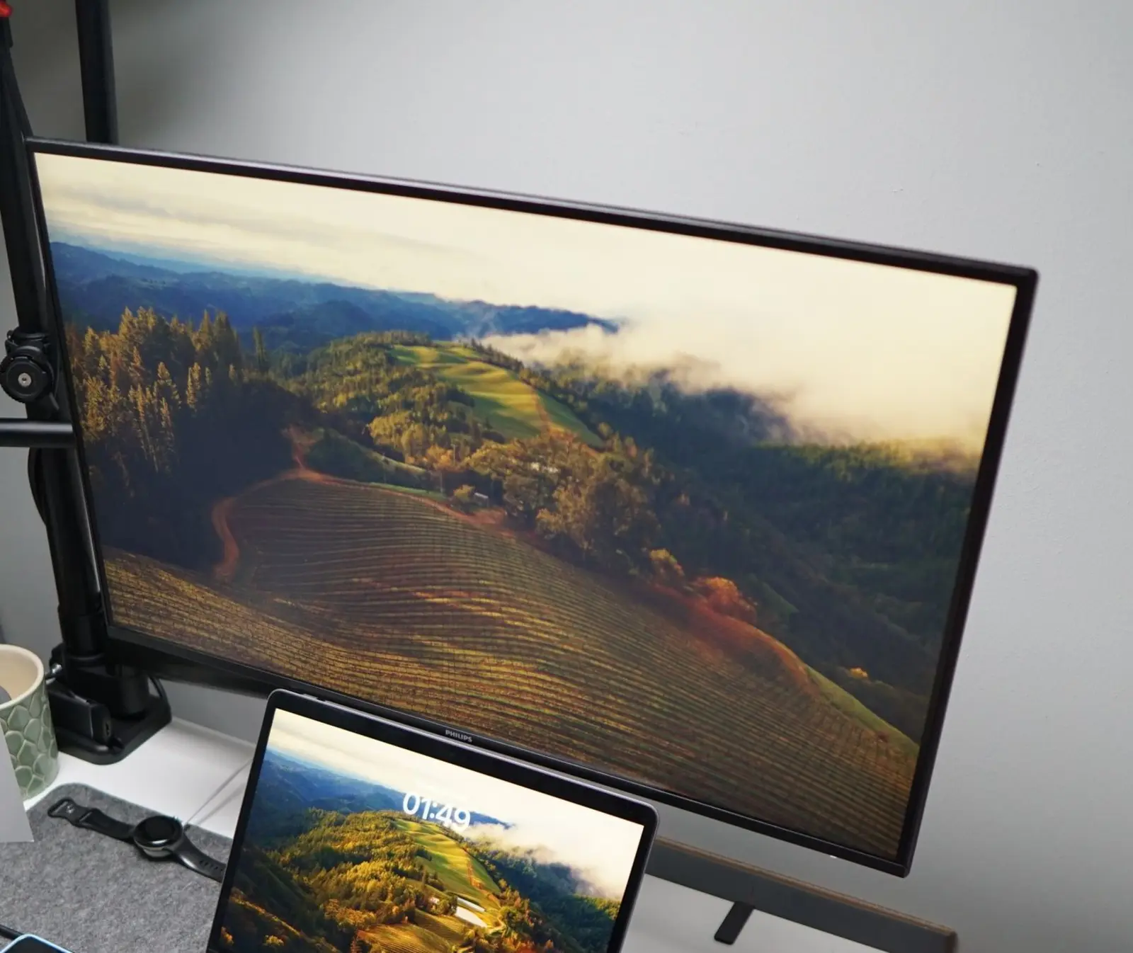 Schreibtisch mit einem großen Monitor und einem Laptop.